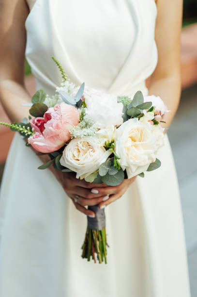 istock Beautiful wedding bouquet in hands of the bride 1360310948