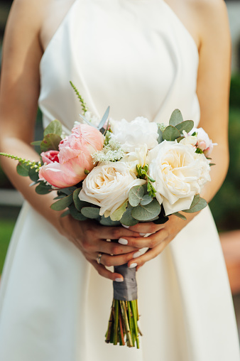 Beautiful wedding bouquet in hands of the bride.