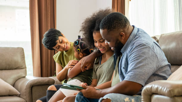 istock Happy African mixed race family using digital tablet together at home. 1360310973