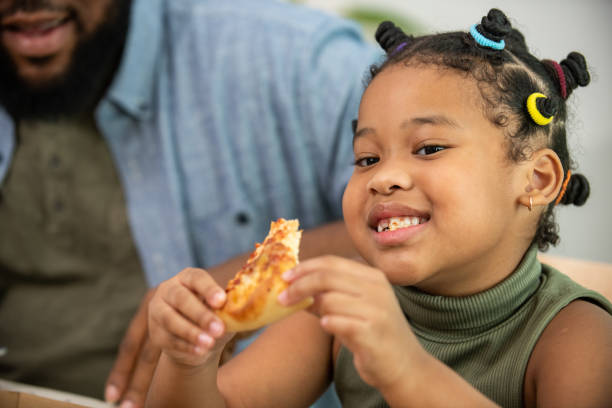 집에서 함께 저녁 식사를 위해 튀긴 닭고기와 피자를 먹는 아프리카 가족 - pizza eating african descent lunch 뉴스 사진 이미지