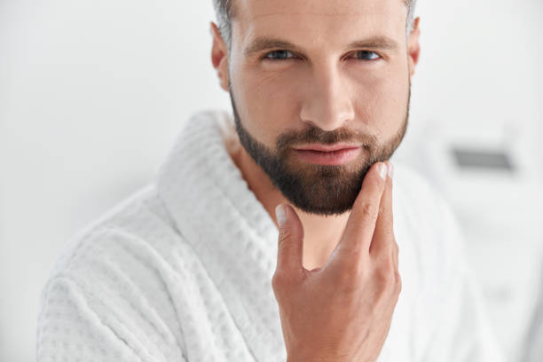 istock Portrait of handsome mature man touching stylish beard on blurred background 1360315480
