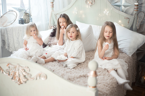 Girls sisters or friends eat sweets in the morning in the bedroom. Winter holidays.