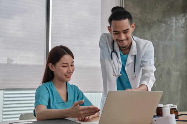 istock Two uniformed young doctors work in medical clinic office. 1360317984