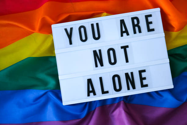 istock Rainbow flag with lightbox and text YOU ARE NOT ALONE. Rainbow lgbtq flag made from silk material. Symbol of LGBTQ pride month. Equal rights. Peace and freedom 1360318872