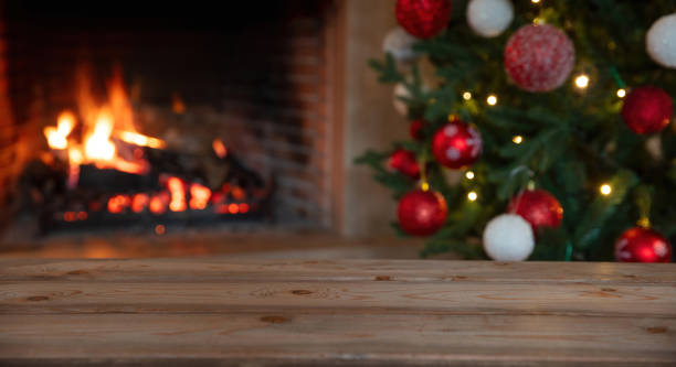 istock Christmas tree and burning fireplace background. Wooden table desk empty, template 1360318972