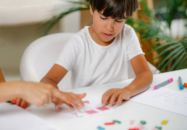 istock Child Recognizing Shapes In A Preschool Assessment Test. 1360320677