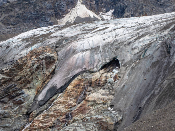 istock Melting glacier texture. Minimalist nature background of glacier surface with big cave and cracks. Minimal natural backdrop of icy wall and blocks of ice from glacier close up. 1360324808