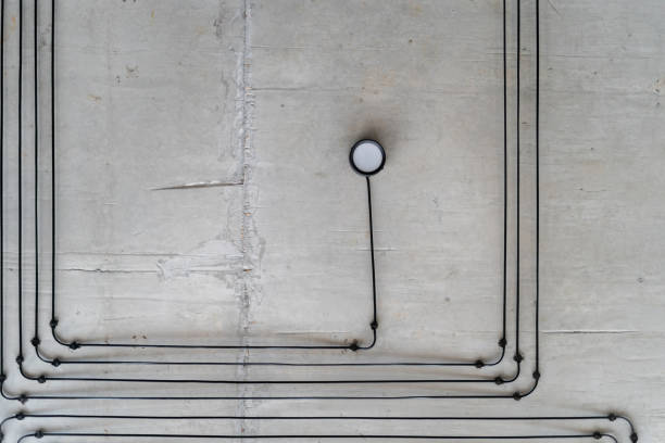 Ceiling lighting on concrete wall during renovation in new apartment. Contemporary electricity installation. Loft styled house renovation process