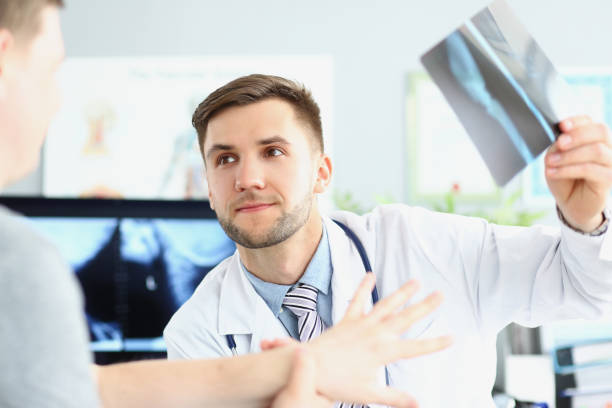 istock Smiling doctor talking with patient about good x ray results 1360325707