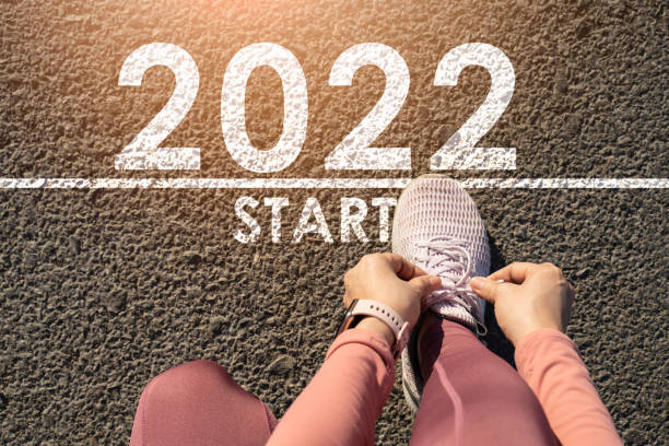 새해 2022 또는 직선 개념을 시작합니다.word 2022 아스팔트 도로에 기록 및 일몰에 새해를 준비 다리 스트레칭 선수 여성 주자. 도전이나 경력 경로와 변화의 개념. - scoring run 뉴스 사진 이미지