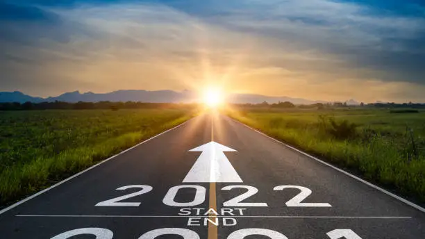 Photo of New year 2022 or start straight concept.word 2022 and strategy written on the road of asphalt road at sunset.Concept of target and challenge or career path,success business,opportunity and change