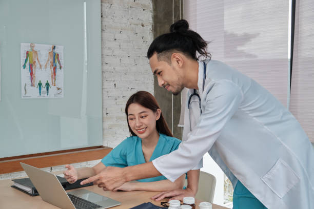 istock Two uniformed young doctors work in medical clinic office. 1360328382