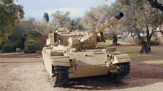 cannon of a green camouflage tank without soldiers