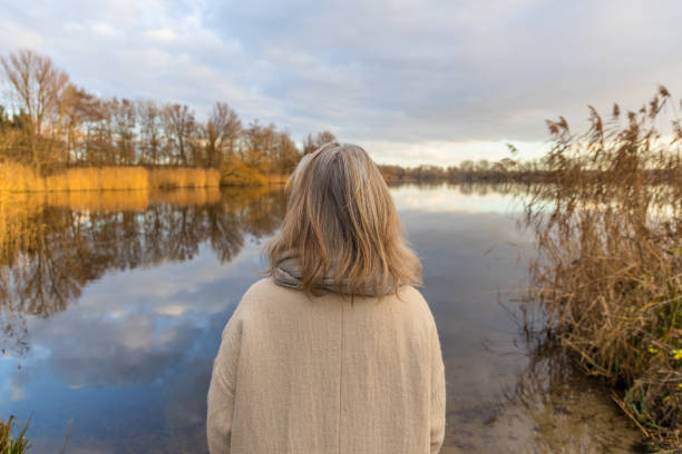 istock woman at the lake at sunset 1360333765