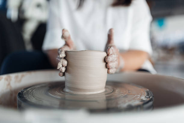 istock Woman sculpts an object on a potter's wheel 1360334701