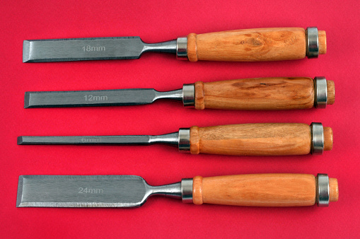 Wood scissors of different sizes on a red background