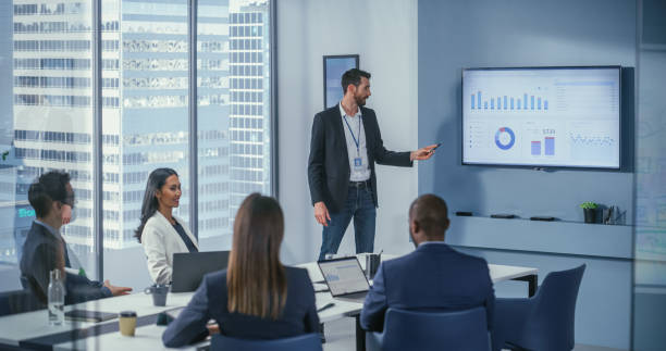 istock Office Conference Room Meeting: Digital Enterpreneur Presents e-Commerce Investment Strategy for Group of Investors. Wall TV Showing Big Data Analysis, Infographics, Stock Market Information, Trends 1360337410