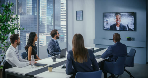 videokonferenz im bürobesprechungsraum: schwarze weibliche führungskräfte sprechen mit einer gruppe multiethnischer digitaler unternehmer, manager und investoren. geschäftsleute diskutieren e-commerce-investitionsstrategie - multi ethnic group professional occupation business person corporate business stock-fotos und bilder