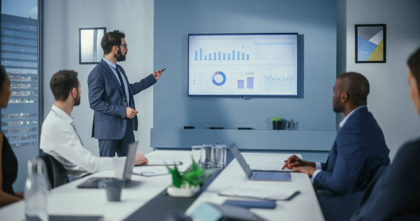 istock Office Conference Room Meeting: Digital Enterpreneur Presents e-Commerce Investment Strategy for Group of Investors. Wall TV Showing Big Data Analysis, Infographics, Stock Market Information, Trends 1360337439