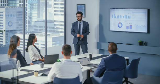 istock Office Conference Room Meeting: Digital Enterpreneur Presents e-Commerce Investment Strategy for Group of Investors. Wall TV Showing Big Data Analysis, Infographics, Stock Market Information, Trends 1360337442