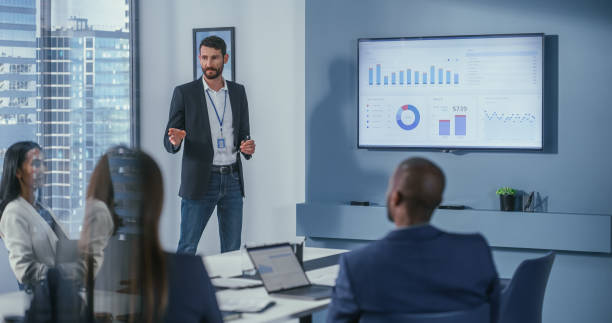 istock Office Conference Room Meeting: Digital Enterpreneur Presents e-Commerce Investment Strategy for Group of Investors. Wall TV Showing Big Data Analysis, Infographics, Stock Market Information, Trends 1360337470