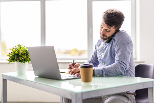 istock Multi-tasking young businessman working in the office. 1360337725