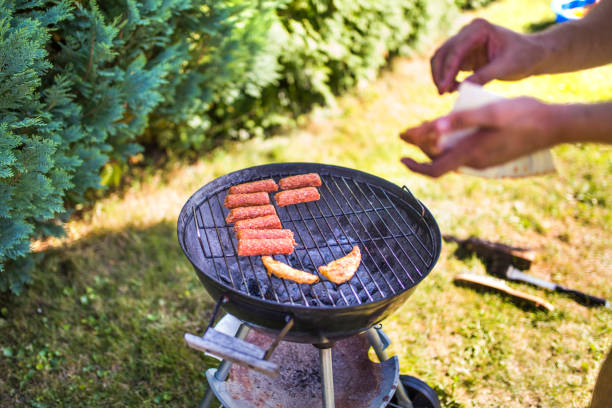 Close up of man grilling meat on barbecue outdoors