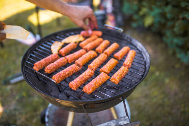 Close up of man grilling meat on barbecue outdoors