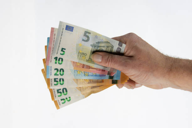 istock Hand holding euro banknotes isolated on white background 1360339425