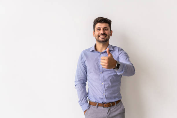 istock Young happy man with thumbs up sign isolated on white background. 1360339988