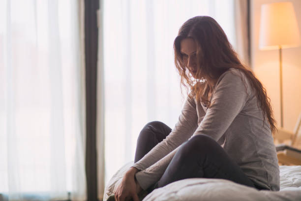 istock Woman sitting on the bed 1360341275