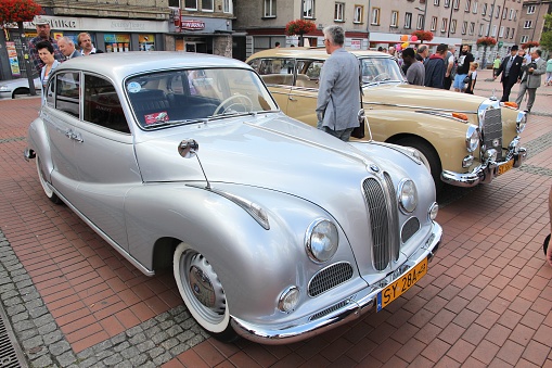 Bytom: People walk by BMW 501 and Mercedes-Benz 300 oldtimer cars during 12th Historic Vehicle Rally in Bytom.
