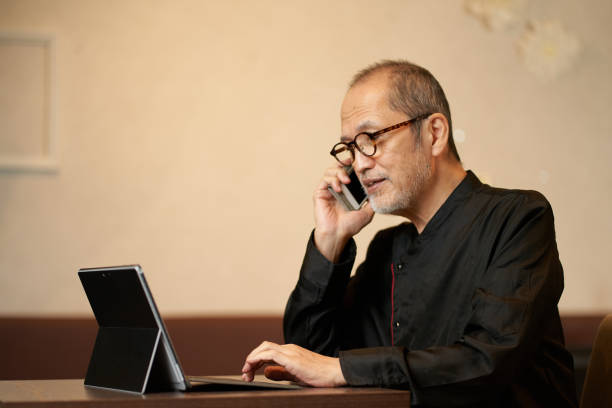 istock The owner of a restaurant who makes a phone call while looking at a computer 1360346509