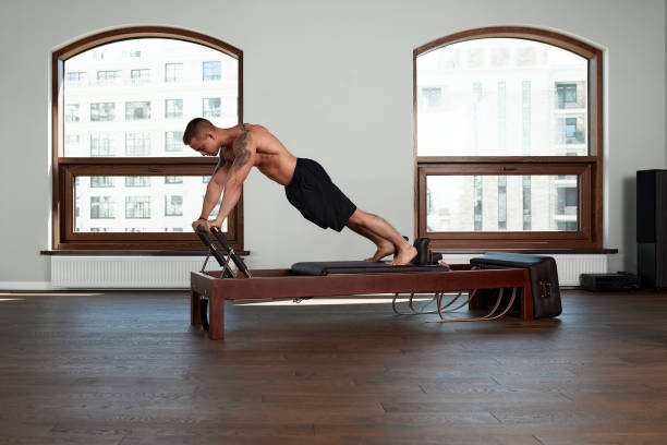 istock Pilates reformer workout exercises man at gym indoor 1360347644
