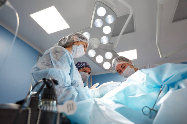 istock Concentrated Surgical team operating a patient in an operation theater 1360348069
