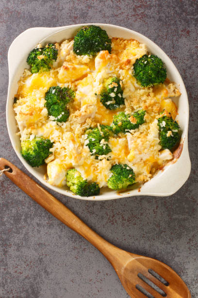 istock Chicken Divan is a creamy casserole that traditionally made with a chicken, broccoli, cream, cheese close up in the dish. vertical top view 1360349156