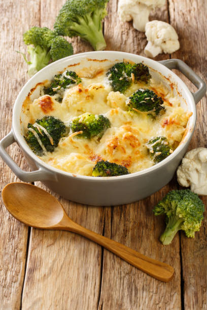 istock Cauliflower and broccoli baked with cheese sauce in a pot close-up on a table. Vertical 1360349187