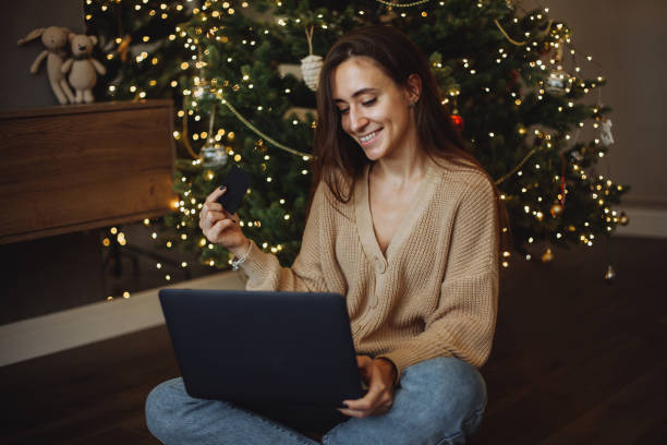 istock Smiling young girl using laptop for online shopping 1360349193
