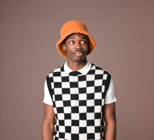 istock Confused young man against brown background 1360351246