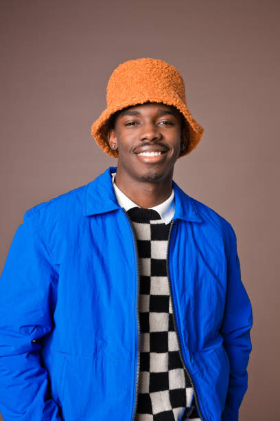 istock Smiling young man against brown background 1360351970