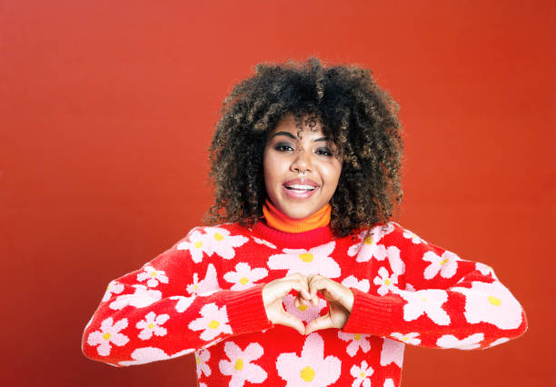 istock Cheerful young woman against red background 1360352524