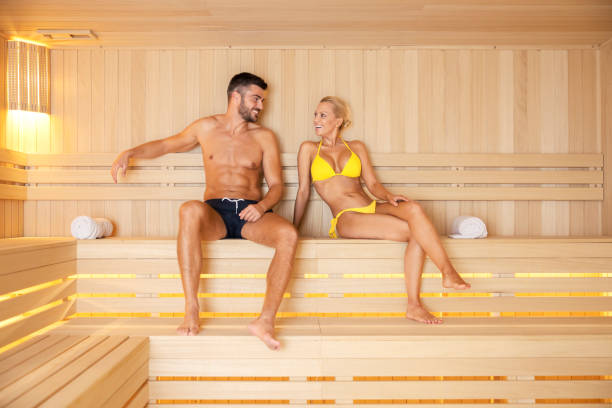 wellness and healthy life. an attractive couple in love in a bathing suit sitting in a hot sauna at spa center and relaxing. - health spa spa treatment couple heterosexual couple imagens e fotografias de stock