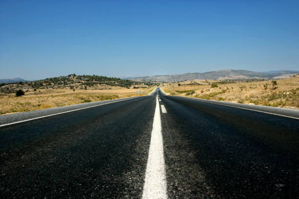 istock Empty single lane asphalt road in mountainside landscape 1360353044
