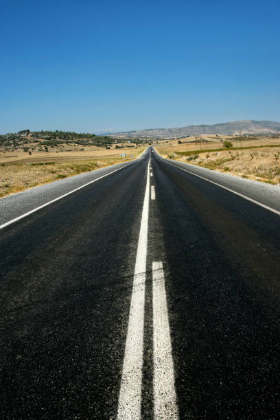 istock Empty single lane asphalt road in mountainside landscape 1360353577