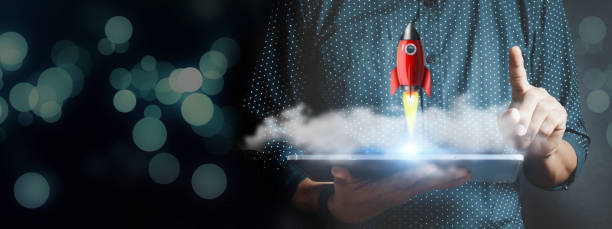istock Businessman holding tablet and icon transparent rocket 1360354320