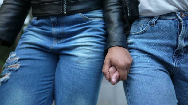 istock Two girlfriends holding hands walking together outside 1360355609