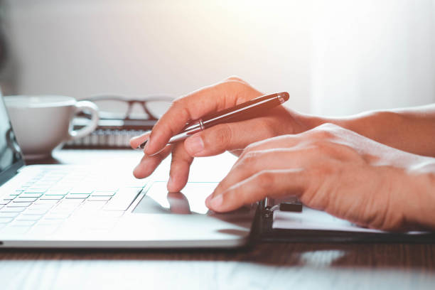 istock Close-up of man hands using and typing keyboard of laptop computer on office desk. 1360359217