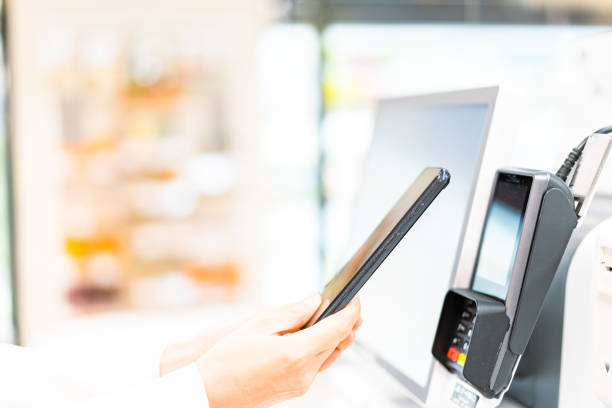 istock Young woman paying with smartphone payment 1360362287