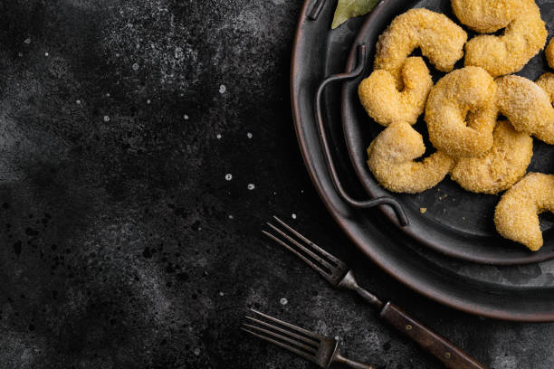 istock Uncooked shrimps in cheese breading, on black dark stone table background, top view flat lay, with copy space for text 1360363921