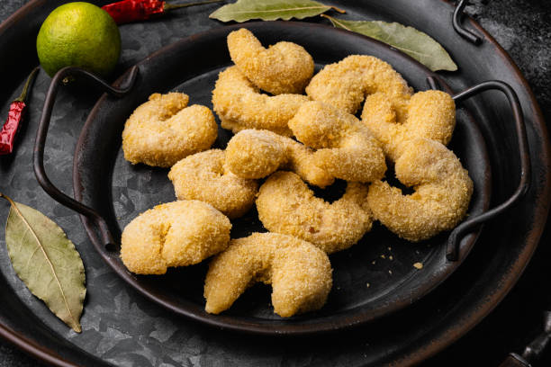 istock Breaded Deep Fried shrimps, on black dark stone table background 1360365025